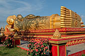 Vientiane, Laos - Pha That Luang, large gilded reclining Buddha within the temple area. 